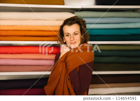 Stylish woman with curly hair in craft textile store, design concept 114654591
