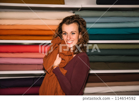 Stylish woman with curly hair in craft textile store, design concept 114654592