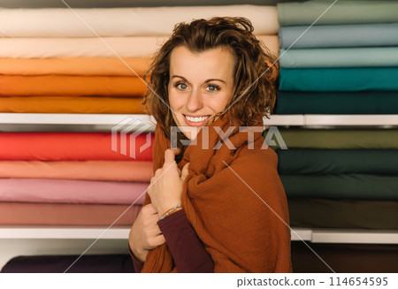 Stylish woman with curly hair in craft textile store, design concept 114654595