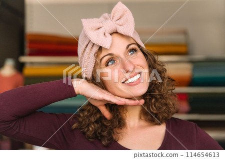 Stylish woman with curly hair in craft textile store, design concept Stylish woman with curly hair in craft textile store, design concept 114654613