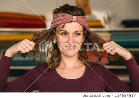 Stylish woman with curly hair in craft textile store, design concept Stylish woman with curly hair in craft textile store, design concept 114654617