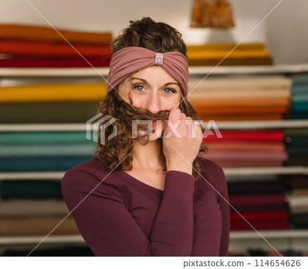 Stylish woman with curly hair in craft textile store, design concept Stylish woman with curly hair in craft textile store, design concept 114654626