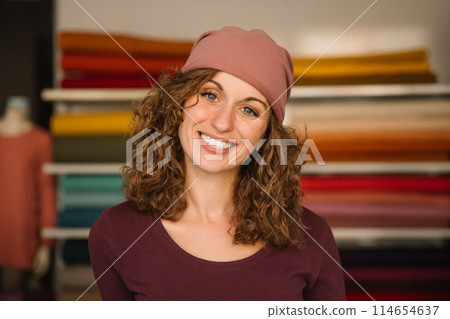Stylish woman with curly hair in craft textile store, design concept 114654637