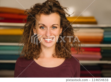 Stylish woman with curly hair in craft textile store, design concept Stylish woman with curly hair in craft textile store, design concept 114654638