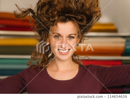 Stylish woman with curly hair in craft textile store, design concept Stylish woman with curly hair in craft textile store, design concept 114654639