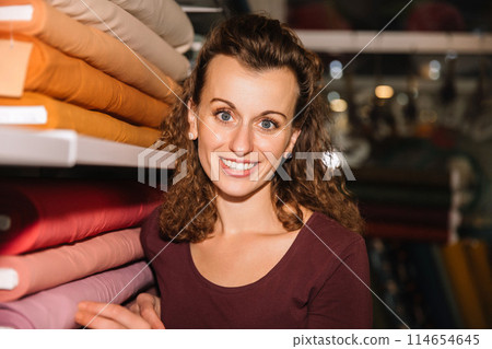 Stylish woman with curly hair in craft textile store, design concept Stylish woman with curly hair in craft textile store, design concept 114654645