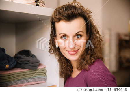 Stylish woman with curly hair in craft textile store, design concept Stylish woman with curly hair in craft textile store, design concept 114654648