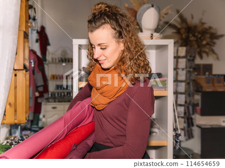 Stylish woman with curly hair in craft textile store, design concept 114654659