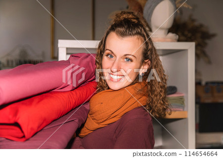 Stylish woman with curly hair in craft textile store, design concept Stylish woman with curly hair in craft textile store, design concept 114654664