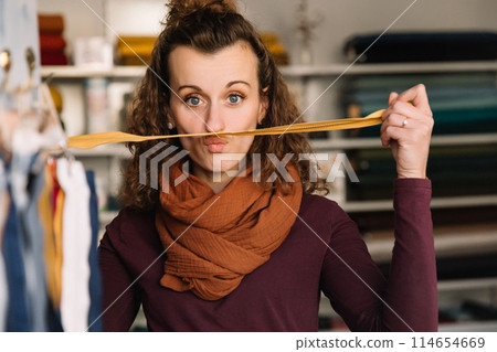 Stylish woman with curly hair in craft textile store, design concept Stylish woman with curly hair in craft textile store, design concept 114654669