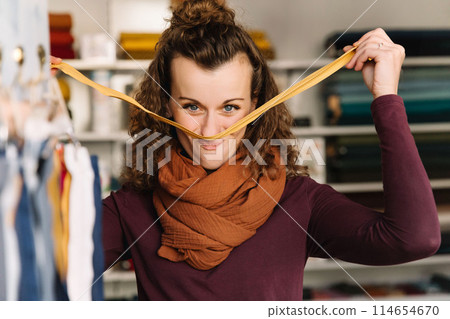 Stylish woman with curly hair in craft textile store, design concept 114654670