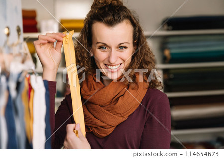 Stylish woman with curly hair in craft textile store, design concept Stylish woman with curly hair in craft textile store, design concept 114654673