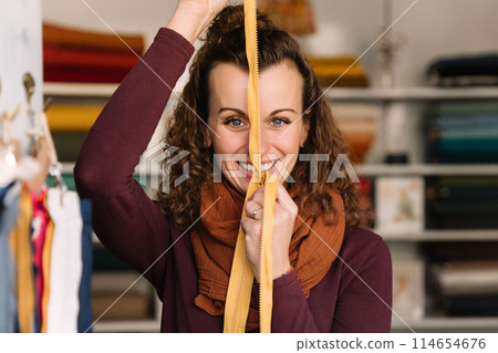 Stylish woman with curly hair in craft textile store, design concept 114654676