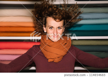 Stylish woman with curly hair in craft textile store, design concept Stylish woman with curly hair in craft textile store, design concept 114654683