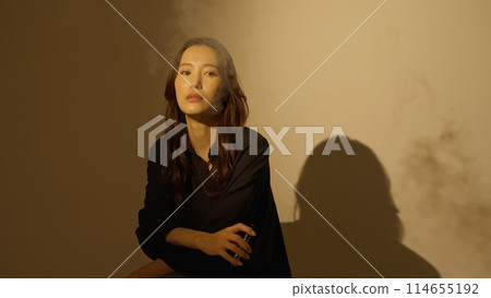 Woman smoking a portable shisha Woman smoking a portable shisha 114655192