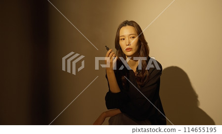 Woman smoking a portable shisha Woman smoking a portable shisha 114655195