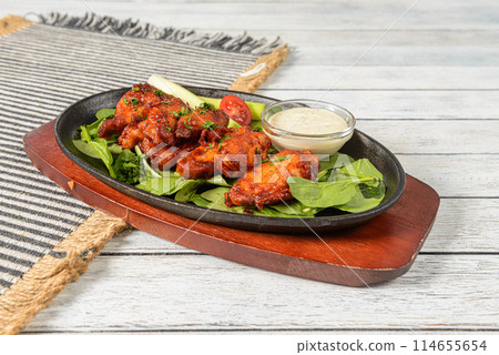 Buffalo Wings are a popular American appetizer or snack, consisting of deep-fried chicken wings coated in a spicy sauce made from hot sauce, butter, and other seasonings. Buffalo Wings are a popular American appetizer or snack, consisting of deep-fried chicken wings coated in a spicy sauce made from hot sauce, butter, and other seasonings. 114655654