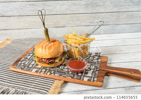 A beef burger is a classic American dish consisting of a ground beef patty, seasoned and grilled, served on a bun. A beef burger is a classic American dish consisting of a ground beef patty, seasoned and grilled, served on a bun. 114655655