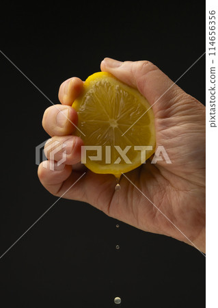Squeezing lemon Black background Squeezing lemon Black background 114656356