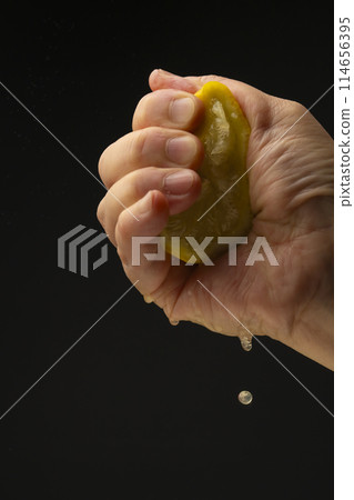 Squeezing lemon Black background Squeezing lemon Black background 114656395