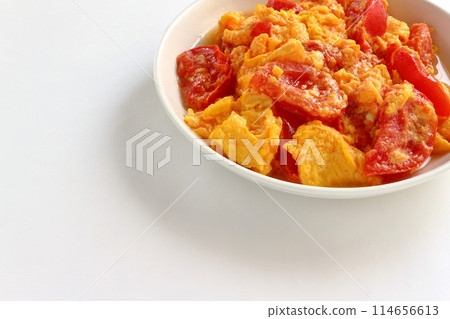 Fried eggs with tomatoes on white background 114656613