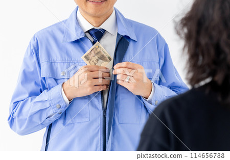 Two men in work clothes holding stacks of bills Two men in work clothes holding stacks of bills 114656788