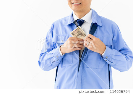 Man in work clothes, stack of bills, no face 114656794