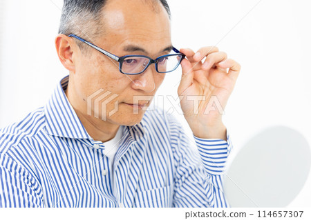 Middle-aged man choosing glasses 114657307