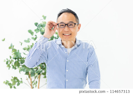 Middle-aged man choosing glasses Middle-aged man choosing glasses 114657313