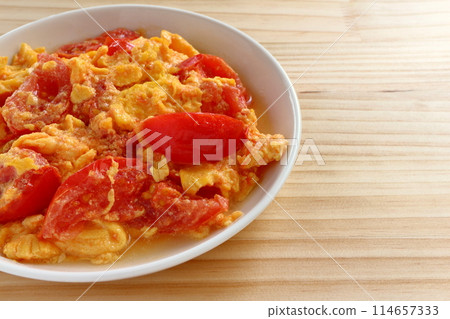 Fried eggs with tomatoes on table background Fried eggs with tomatoes on table background 114657333