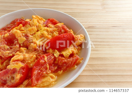 Fried eggs with tomatoes on table background Fried eggs with tomatoes on table background 114657337