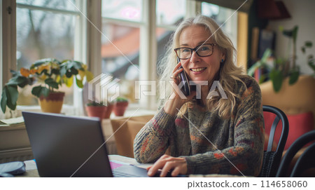 Adult woman from Norway talking on the phone, businesswoman freelancing from a cafe, laptop standing on the table in front of her, copy space for concept 114658060