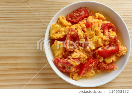 Fried eggs with tomatoes on table background Fried eggs with tomatoes on table background 114658322