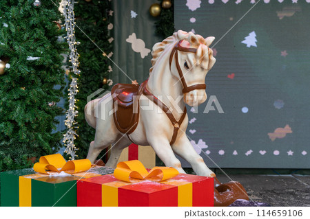 white baby horse a white baby horse next to a Christmas tree and gift boxes. New Year decorations white baby horse a white baby horse next to a Christmas tree and gift boxes. New Year decorations 114659106