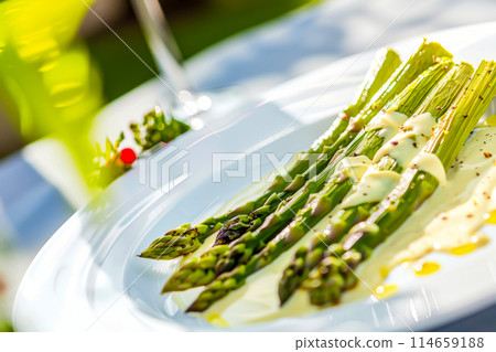 Tender asparagus spears are delicately roasted and combined with creamy hollandaise sauce, creating a harmony of flavors that celebrates the freshness of spring. Ideal for discerning connoisseurs 114659188