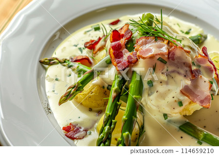 Tender spears of asparagus wrapped in smoked bacon, accompanied by golden fried potatoes and cheese sauce. A hearty yet elegant dish that celebrates the flavors of the earth and garden. 114659210