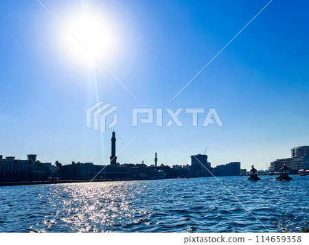 Stylish panoramicview of the historic part of Dubai, against the sun with ships Stylish panoramicview of the historic part of Dubai, against the sun with ships 114659358