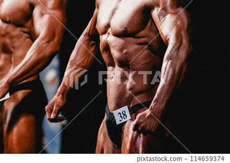 two bodybuilder athlete show front pose in bodybuilding competition two bodybuilder athlete show front pose in bodybuilding competition 114659374