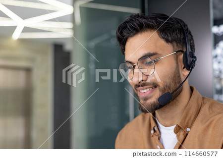 Smiling call center agent wearing a headset, providing customer support in a modern office environment. Smiling call center agent wearing a headset, providing customer support in a modern office environment. 114660577