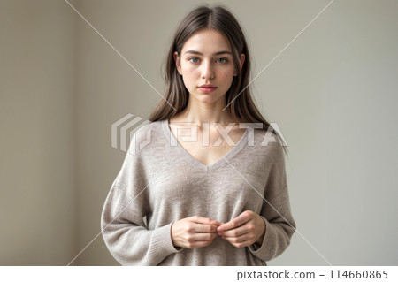Serene Woman Posing in a Softly Lit Room Near a Window pastel tone and mood of the quiet luxury look. 114660865