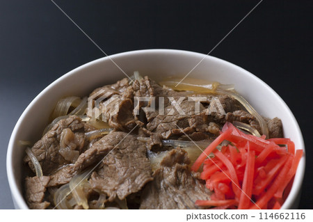 Photo of beef bowl topped with pickled ginger on a black background 114662116