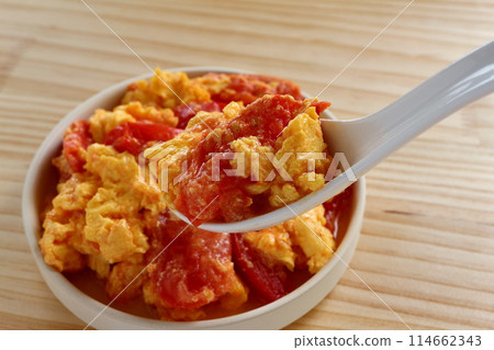 Fried eggs with tomatoes on table background Fried eggs with tomatoes on table background 114662343