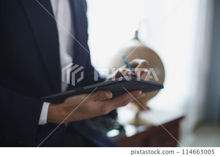 Closeup of digital tablet, successful businessman pointing typing touchpad working at office. 114663005