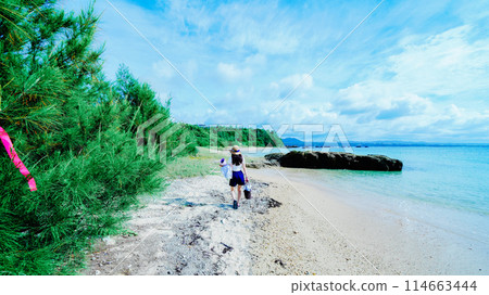 A woman doing yoga on a private beach in Okinawa 114663444