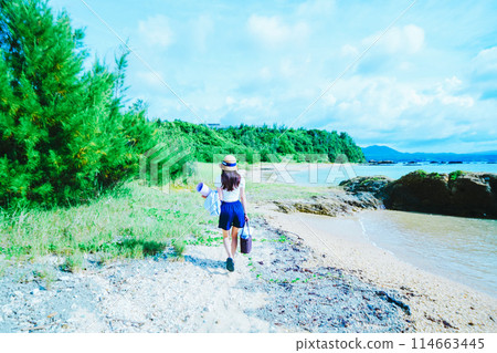 A woman doing yoga on a private beach in Okinawa 114663445