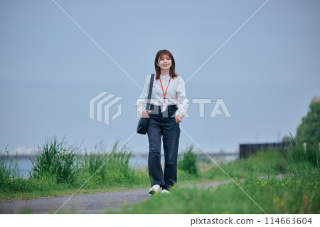 一位年輕的女士，沿著河邊散步 114663604