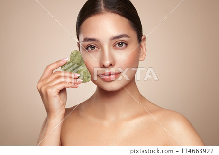 Young woman doing scrapping massage facial skin 114663922