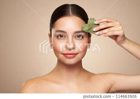Young woman doing scrapping massage facial skin 114663926