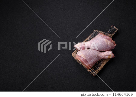 Raw chicken legs with salt, spices and herbs 114664109