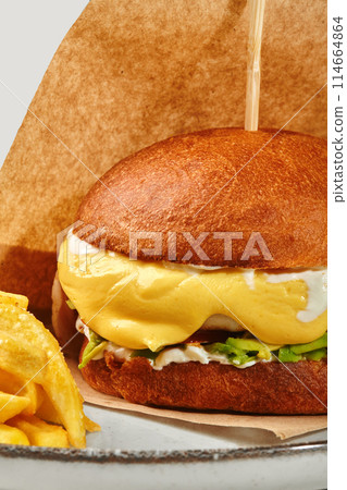 Burger with chicken patty, avocado and creamy cheese sauce 114664864